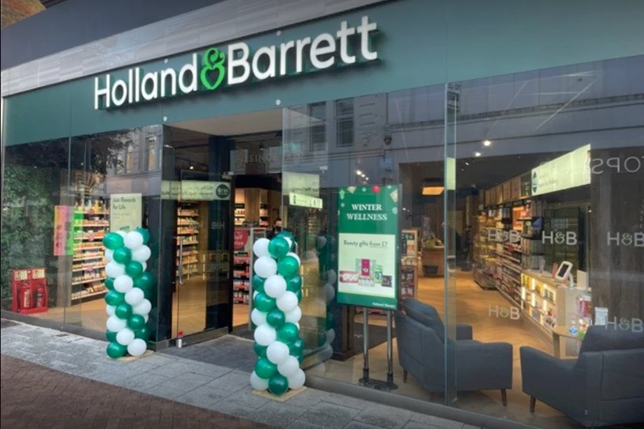 Bright green shop front with chairs in the window and a range of products visible.