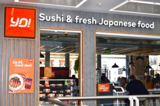 Image of Yo!Sushi front shop with bar stools and people eating